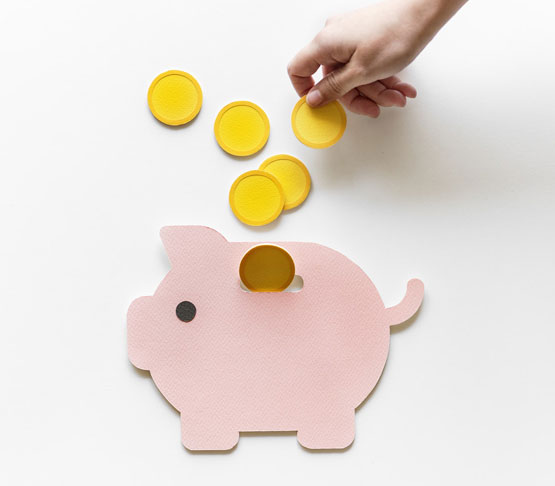 Putting coins into a piggy bank